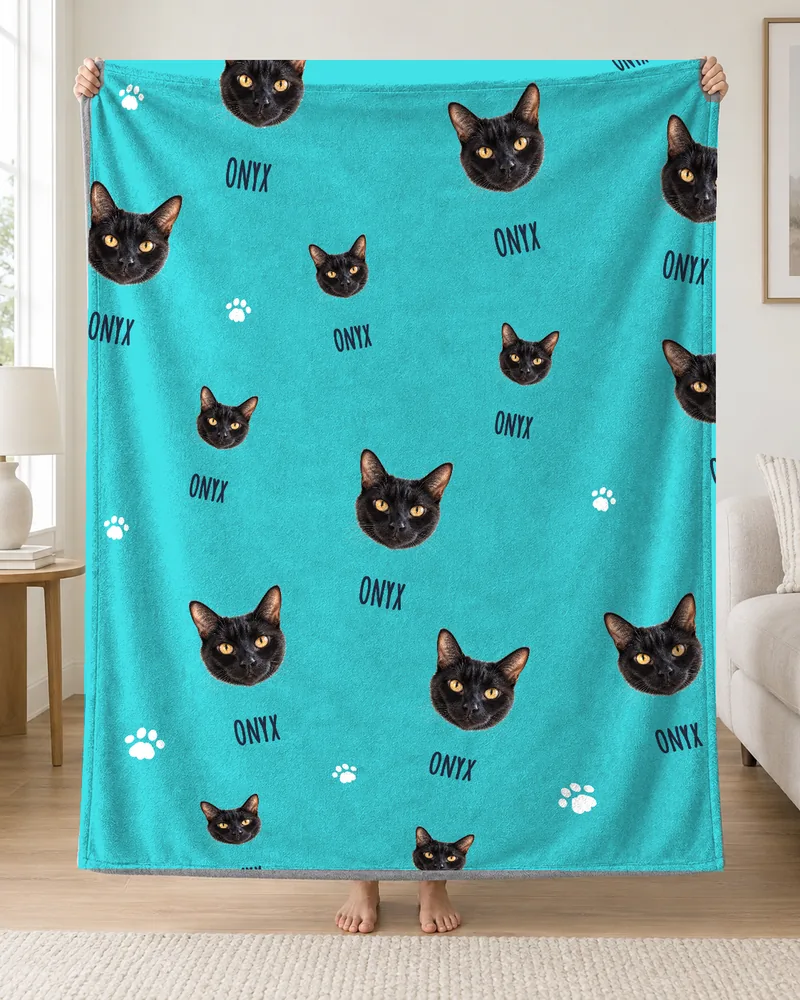 Personalized turquoise blanket with Onyx’s face and name in a repeating pattern.