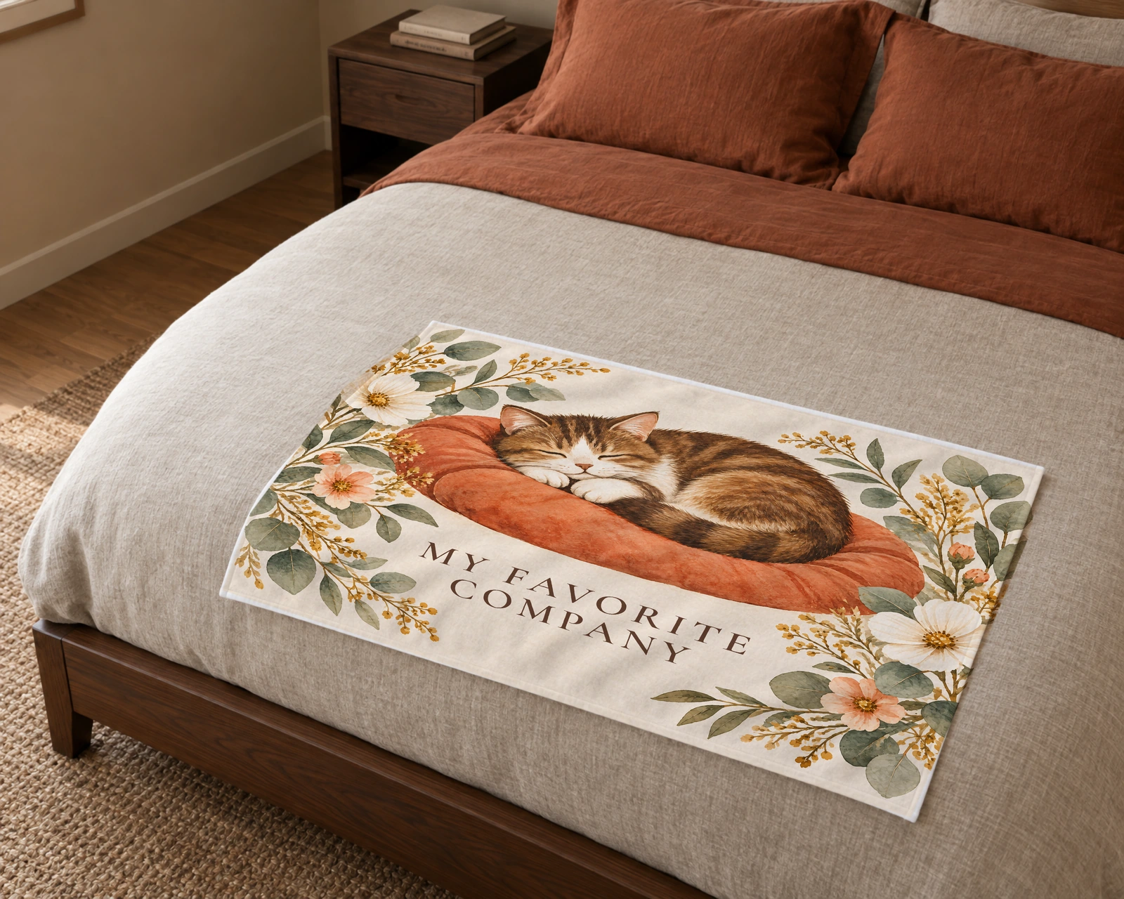 Cream blanket across a bed with a sleeping brown-and-white tabby in watercolor and My Favorite Company.