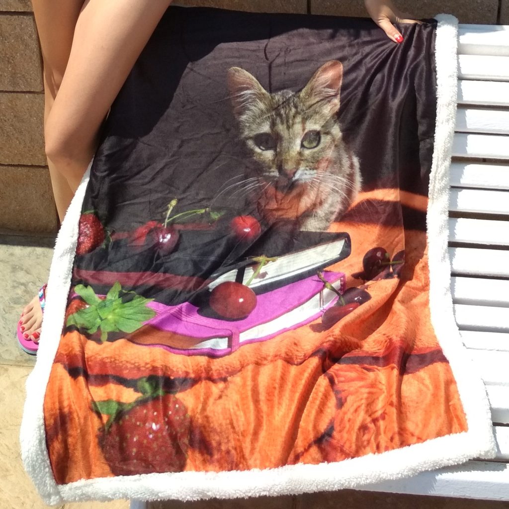 A sherpa blanket printed with China’s photo, held up outdoors