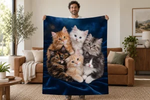 Man holding open a midnight blue blanket with six fluffy kittens on velvet folds beneath soft golden lights in a bright room.