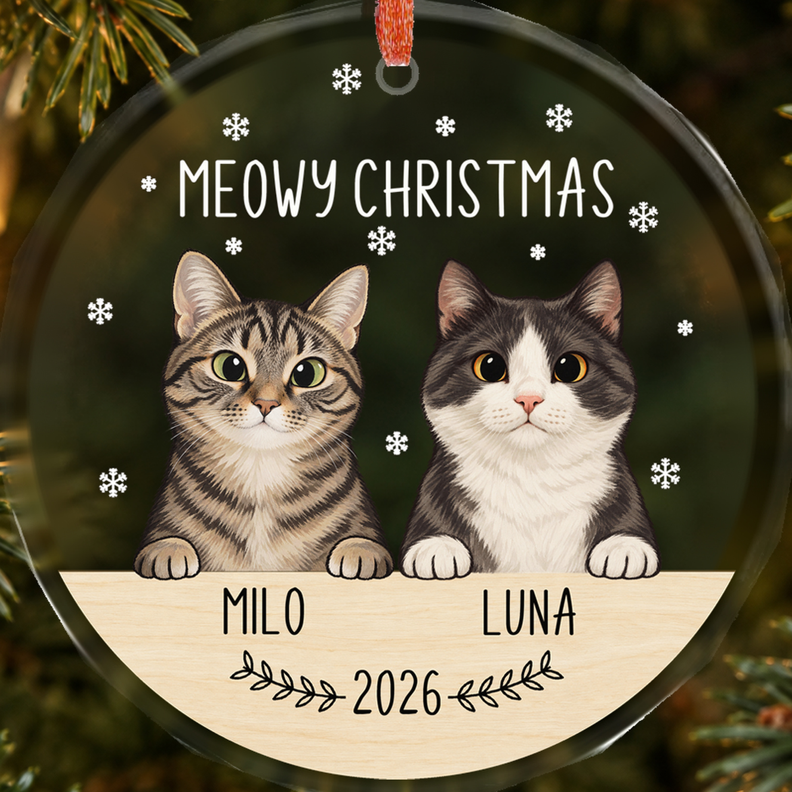 Close-up of Milo and Luna portraits, personalized names and 2026 on a transparent faceted glass Christmas ornament