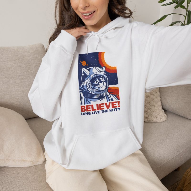 Person wearing a hoodie showing a gray tabby astronaut, a ringed golden planet and stars on deep blue