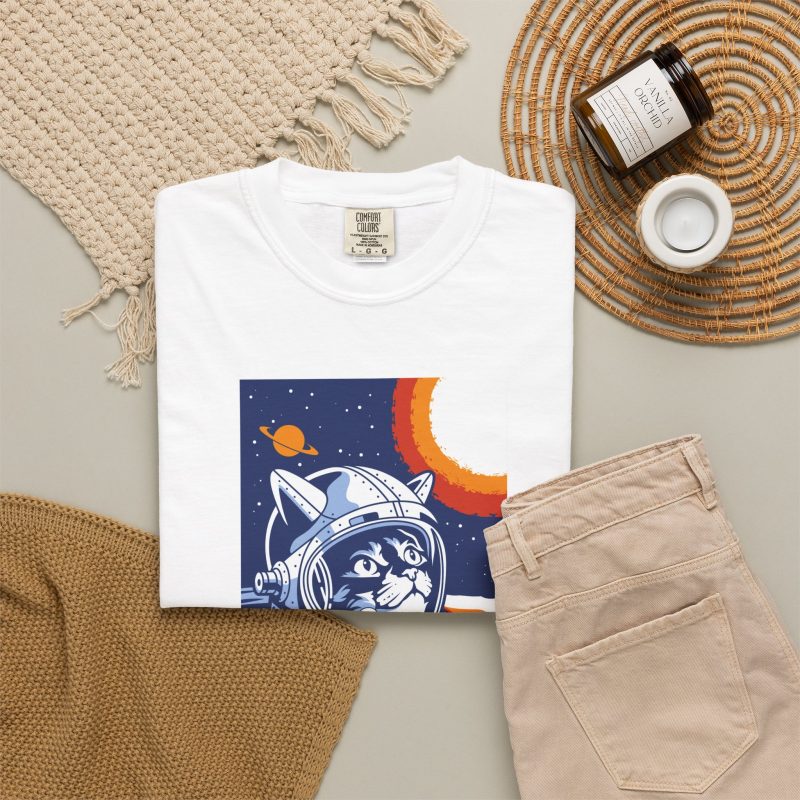 Close view of a gray tabby astronaut, a ringed golden planet and stars on deep blue in the front print