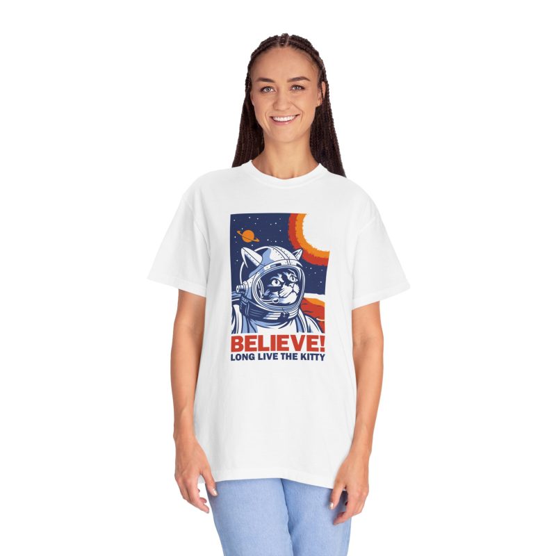 Person wearing a tee showing a gray tabby astronaut, a ringed golden planet and stars on deep blue