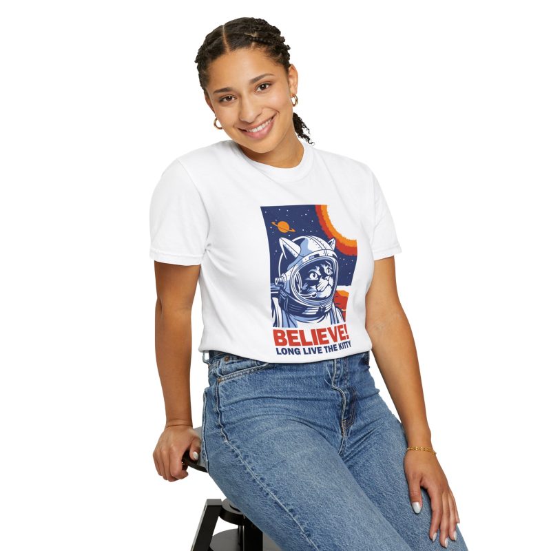 Person wearing a tee showing a gray tabby astronaut, a ringed golden planet and stars on deep blue