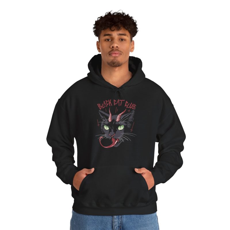 Person wearing a hoodie showing a horned black cat with green eyes, a curling red tongue and angular red lettering