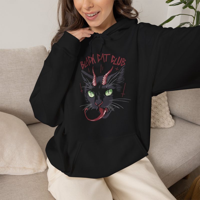 Person wearing a hoodie showing a horned black cat with green eyes, a curling red tongue and angular red lettering