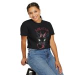 Person wearing a tee showing a horned black cat with green eyes, a curling red tongue and angular red lettering