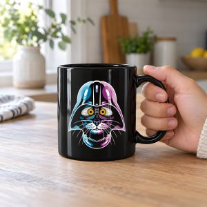 Person holding a glossy black ceramic mug showing an amber-eyed cat in a dark sci-fi helmet with cyan, magenta and white highlights