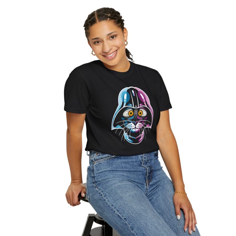 Person wearing a tee showing an amber-eyed cat in a dark sci-fi helmet with cyan, magenta and white highlights