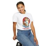 Person wearing a tee showing a giant brown tabby holding a blue fish above waves in front of a red sun disc