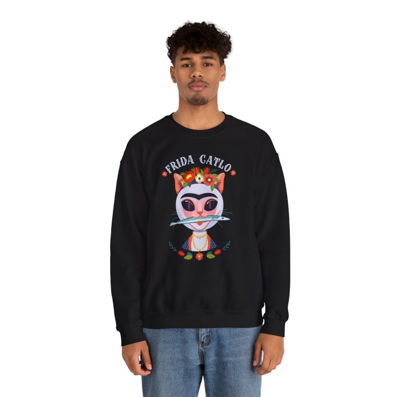 Person wearing a crewneck sweatshirt with a pale pink cat with a unibrow, a flower crown, gold beads and a teal fish printed on the front