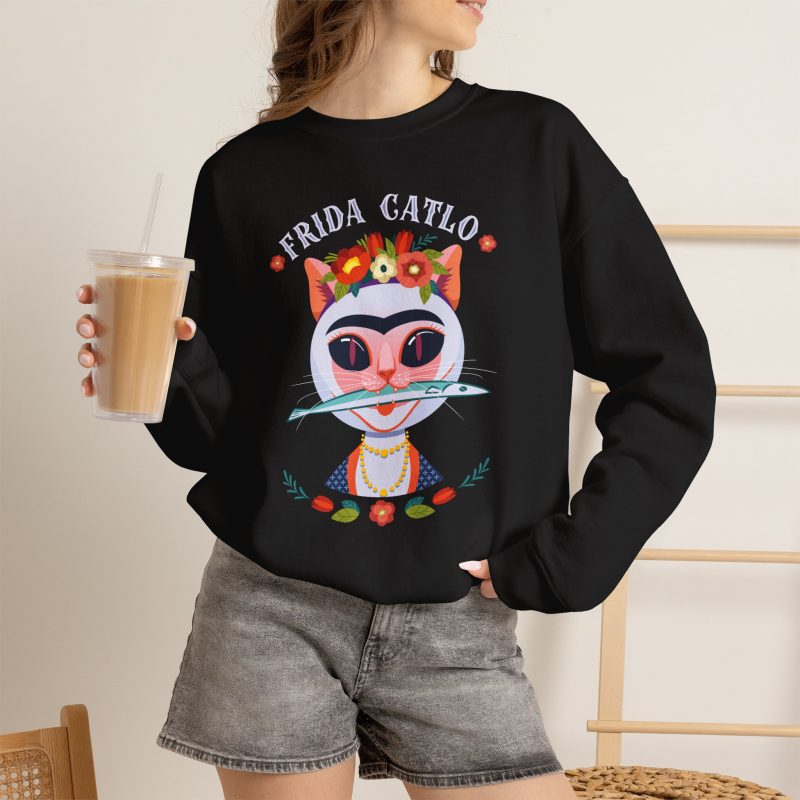 Person wearing a crewneck sweatshirt with a pale pink cat with a unibrow, a flower crown, gold beads and a teal fish printed on the front
