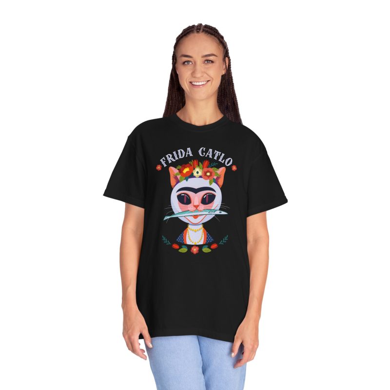 Person wearing a tee with a pale pink cat with a unibrow, a flower crown, gold beads and a teal fish printed on the front