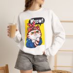 Person wearing a crewneck sweatshirt with a white and ginger cat flexing its paw in a blue work shirt and red polka-dot bandana on a yellow panel printed on the front