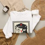 A black and cream cat in a military cap with a red star above a red banner inside a double poster border in the front print A black and cream cat in a military cap with a red star above a red banner inside a double poster border in the front print