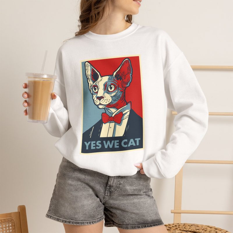Person wearing a crewneck sweatshirt with a hairless cat in a suit and red bow tie printed on the front