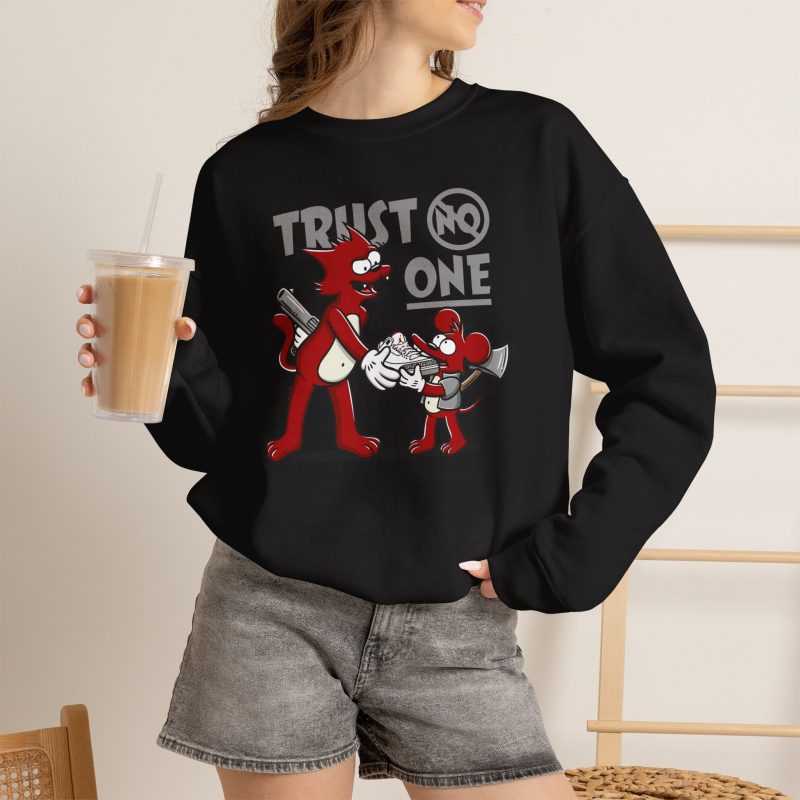 Person wearing a crewneck sweatshirt with a red cartoon cat and mouse trading a sneaker printed on the front