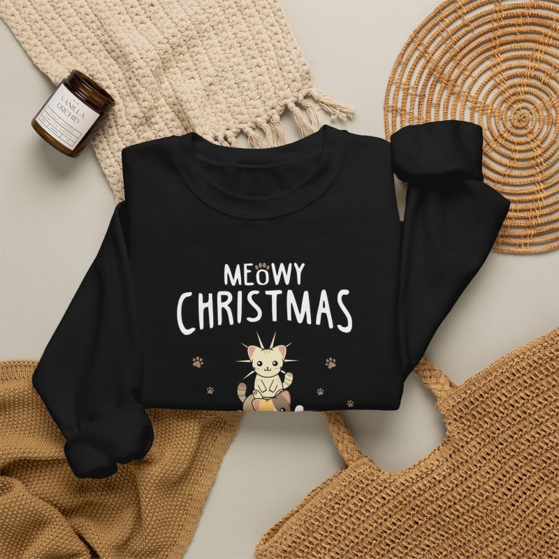 Stacked kittens, paw prints, a starburst and white MEOWY CHRISTMAS lettering in the front print