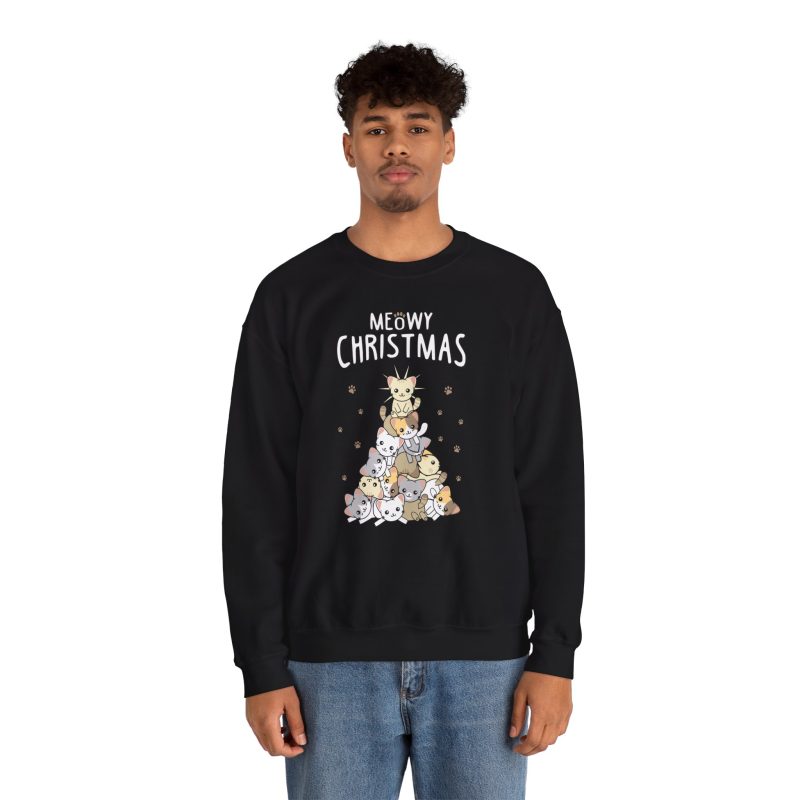 Person wearing a crewneck sweatshirt with white, gray, cream and ginger kittens stacked into a Christmas tree, surrounded by paw prints beneath white lettering printed on the front