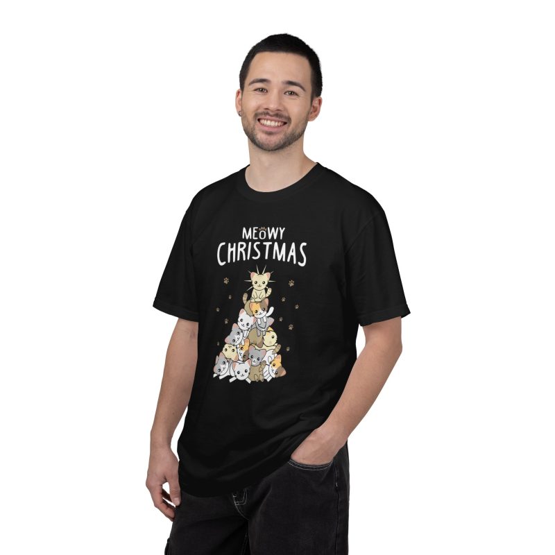 Person wearing a tee with white, gray, cream and ginger kittens stacked into a Christmas tree, surrounded by paw prints beneath white lettering printed on the front