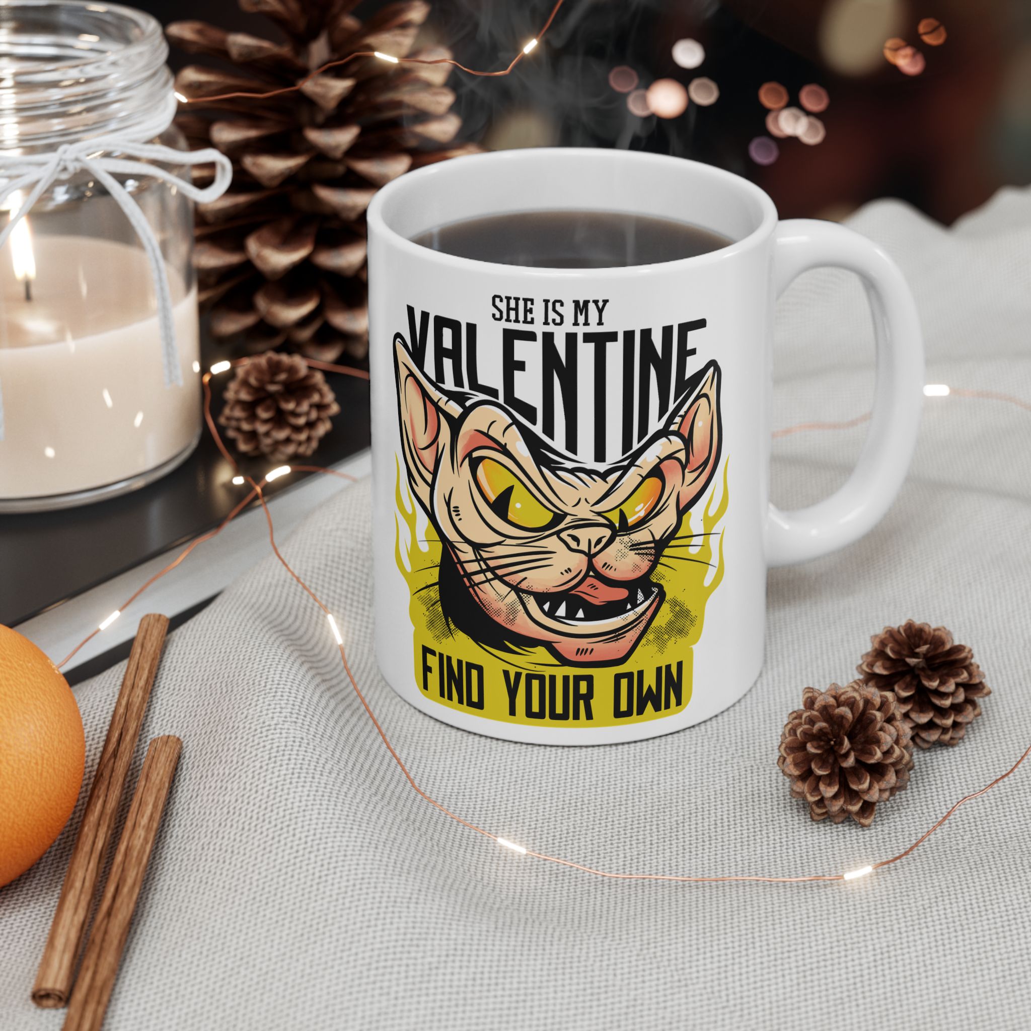 White ceramic mug showing a fierce hairless cat with yellow eyes and flames