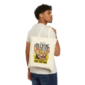 Person carrying a natural canvas tote with a fierce hairless cat with yellow eyes and flames facing outward