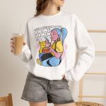 Person wearing a crewneck sweatshirt with a blue-haired girl eating ramen beside a golden ginger cat printed on the front