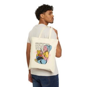 Person carrying a natural canvas tote showing a blue-haired girl eating ramen beside a golden ginger cat