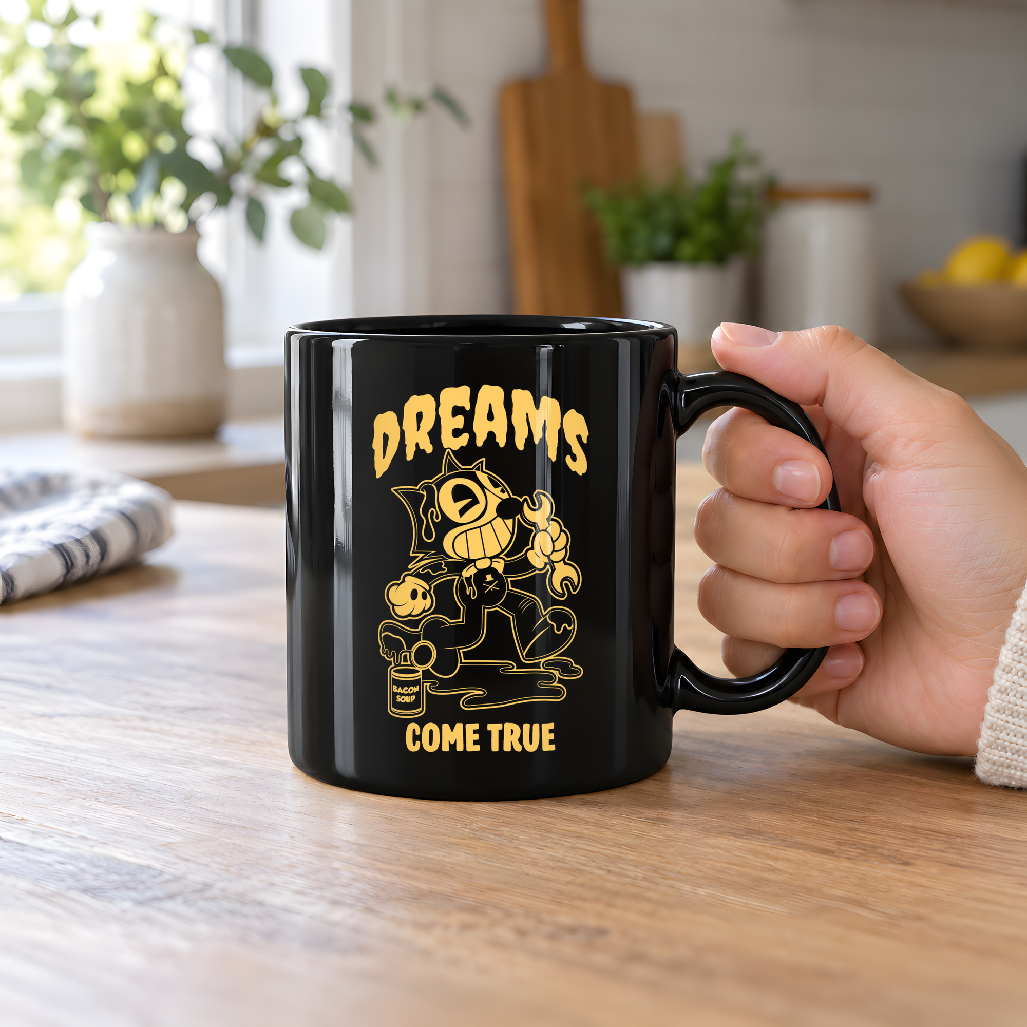 Person holding a glossy black ceramic mug showing a grinning rubber-hose cartoon cat holding a wrench