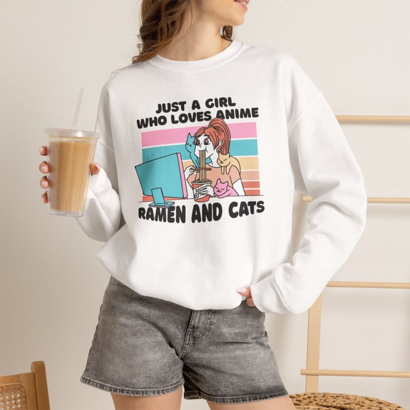 Person wearing a crewneck sweatshirt with a ramen-eating girl at a computer with three colorful cats printed on the front