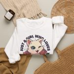 Winking pale cream cat framed by red roses and green leaves and bold lettering in the front print