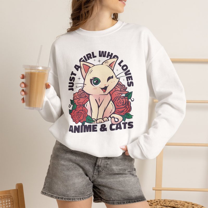 Person wearing a crewneck sweatshirt with a winking pale cream cat framed by red roses and green leaves printed on the front