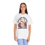 Person wearing a tee with a winking pale cream cat framed by red roses and green leaves printed on the front