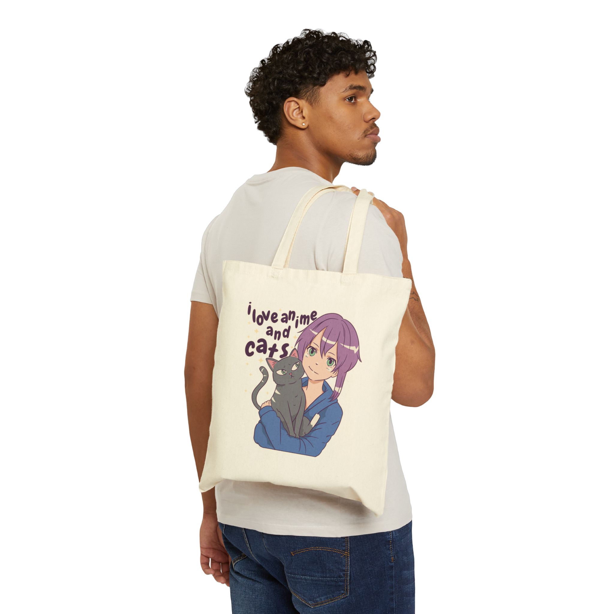 Person carrying a natural canvas tote showing a lilac-haired anime girl hugging a green-eyed gray cat
