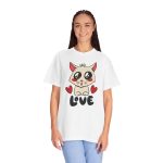 Person wearing a tee with a cream cat with glossy black eyes and red cheeks between two red hearts above black lettering printed on the front Person wearing a tee with a cream cat with glossy black eyes and red cheeks between two red hearts above black lettering printed on the front