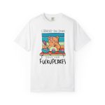 Front of the tee showing a ginger baker cat with a pink whisk, cupcakes and turquoise retro stripes Front of the tee showing a ginger baker cat with a pink whisk, cupcakes and turquoise retro stripes