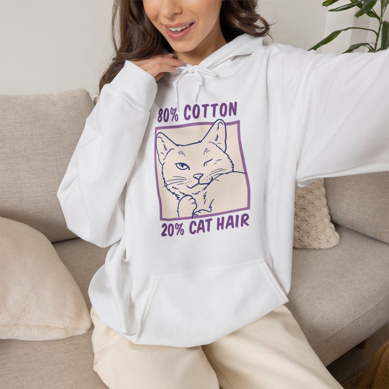 Person wearing a hoodie with a winking white cat drawn in blue inside a cream square with purple lettering printed on the front