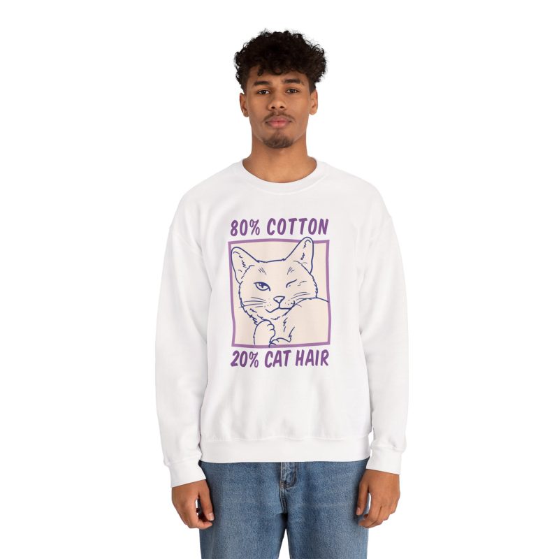 Person wearing a crewneck sweatshirt with a winking white cat drawn in blue inside a cream square with purple lettering printed on the front