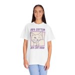 Person wearing a tee with a winking white cat drawn in blue inside a cream square with purple lettering printed on the front