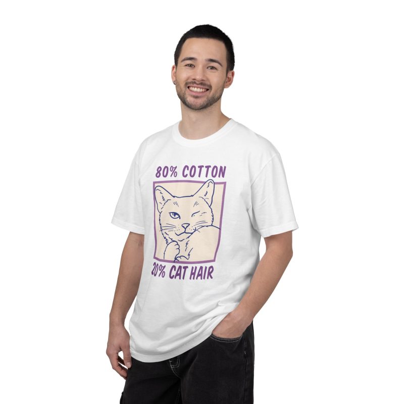 Person wearing a tee with a winking white cat drawn in blue inside a cream square with purple lettering printed on the front