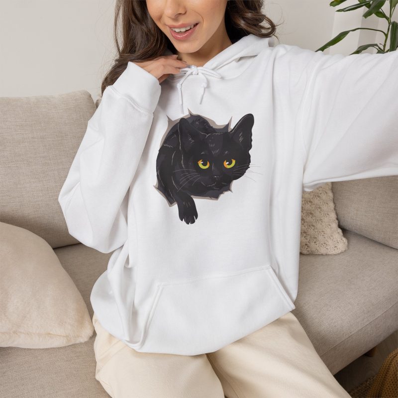 Person wearing a hoodie with an illustrated black cat with yellow-green eyes and a paw reaching through a gray torn-hole effect printed on the front