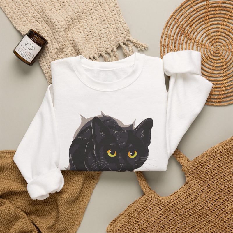 An illustrated black cat with yellow-green eyes and a paw reaching through a gray torn-hole effect in the front print