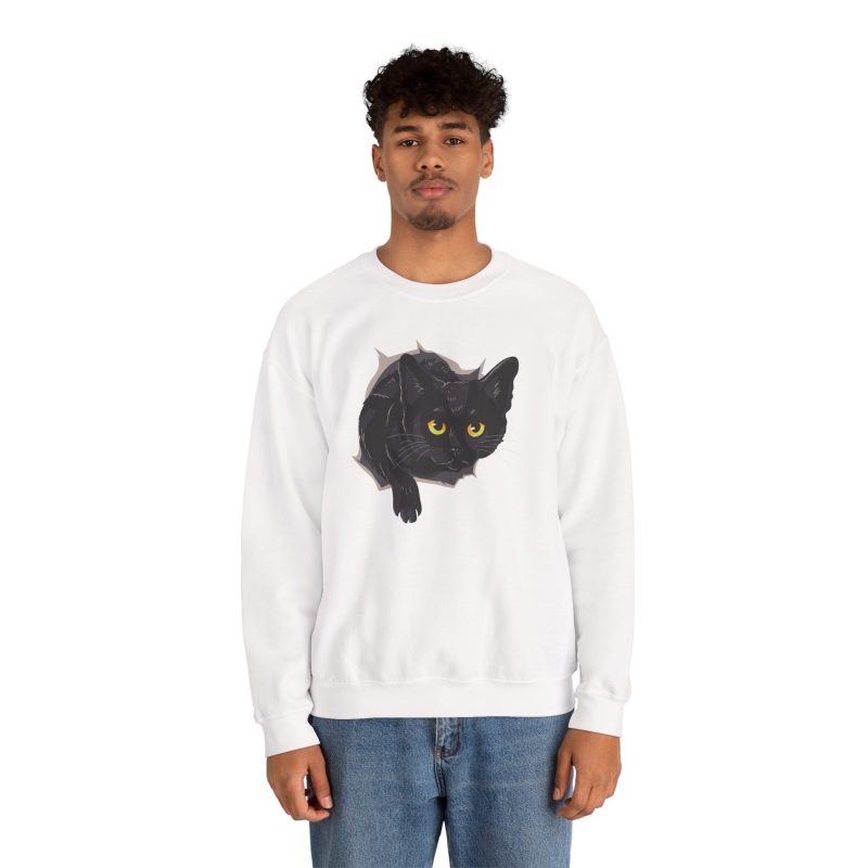 Person wearing a crewneck sweatshirt with an illustrated black cat with yellow-green eyes and a paw reaching through a gray torn-hole effect printed on the front