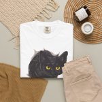 An illustrated black cat with yellow-green eyes and a paw reaching through a gray torn-hole effect in the front print
