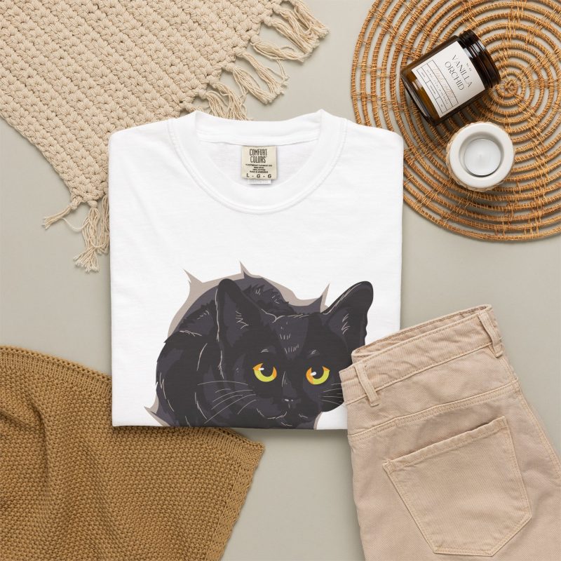 An illustrated black cat with yellow-green eyes and a paw reaching through a gray torn-hole effect in the front print