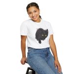 Person wearing a tee with an illustrated black cat with yellow-green eyes and a paw reaching through a gray torn-hole effect printed on the front
