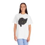 Person wearing a tee with an illustrated black cat with yellow-green eyes and a paw reaching through a gray torn-hole effect printed on the front