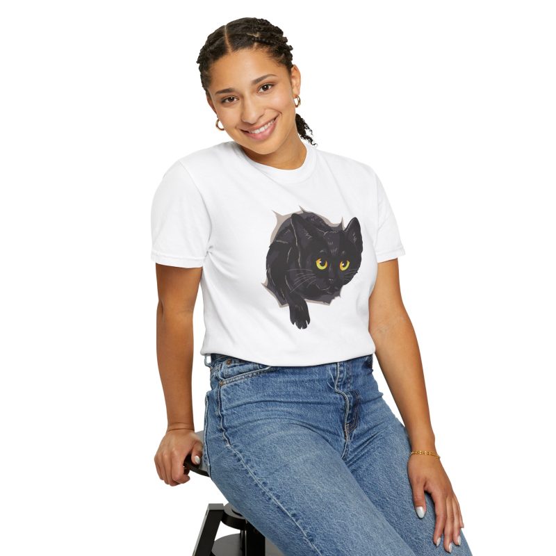 Person wearing a tee with an illustrated black cat with yellow-green eyes and a paw reaching through a gray torn-hole effect printed on the front