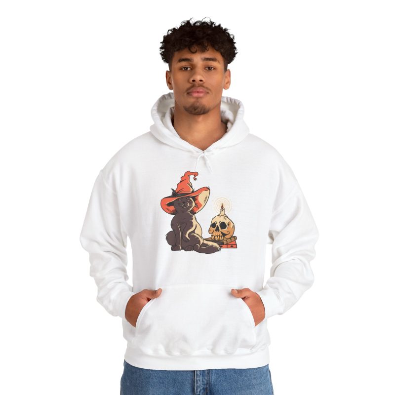 Person wearing a hoodie with a brown cat in an orange witch hat beside a skull, lit candle and stacked spell books printed on the front